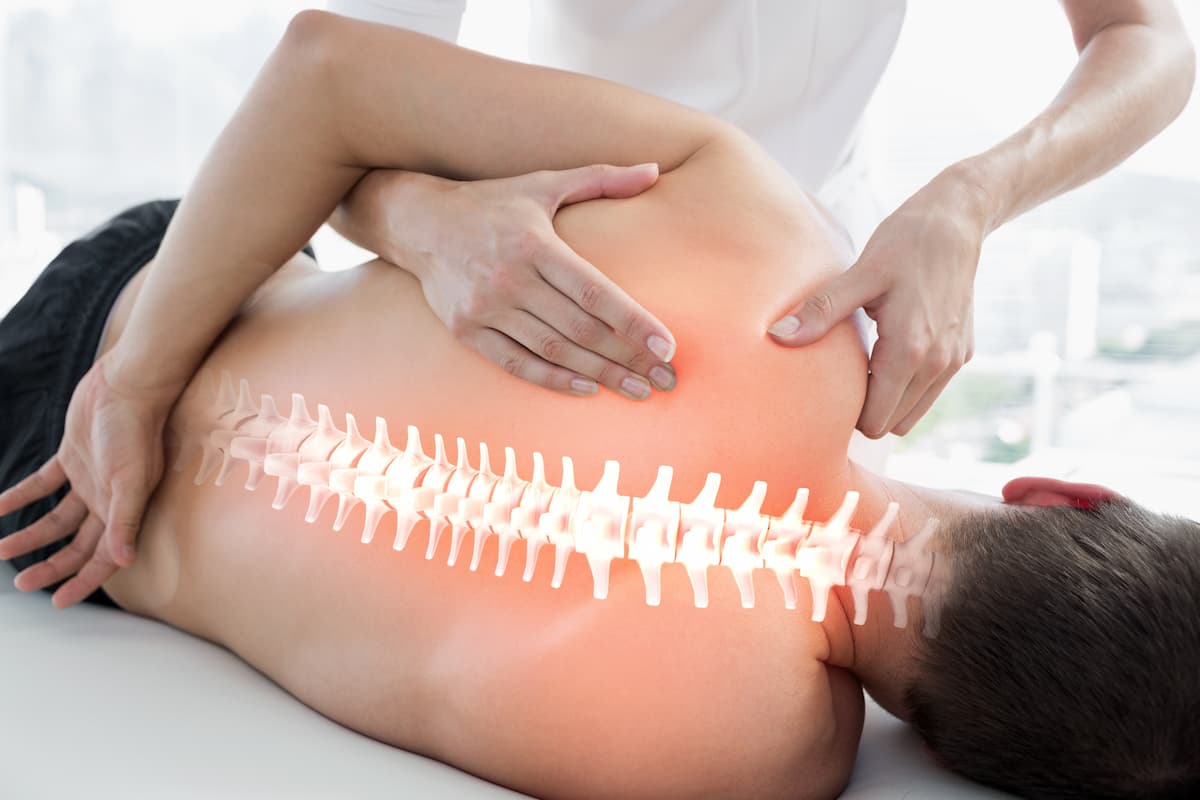 fisioterapeuta masajeando espalda de paciente con dolor